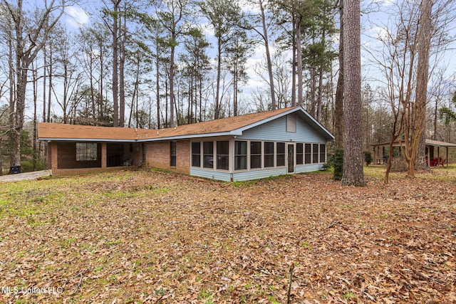 view of front facade featuring a sunroom and brick siding