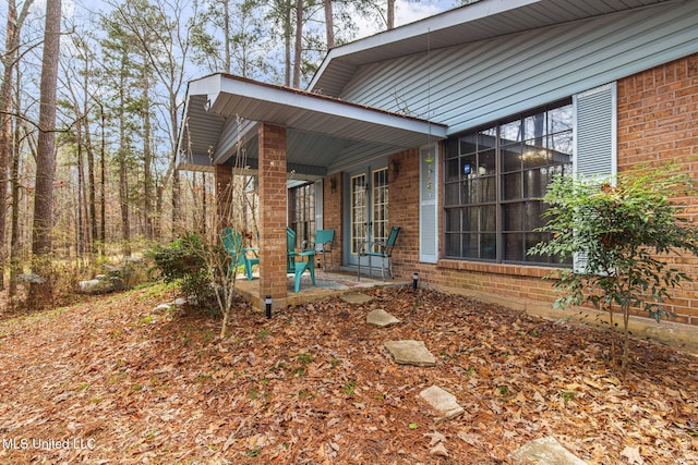 view of side of home with a patio area and brick siding