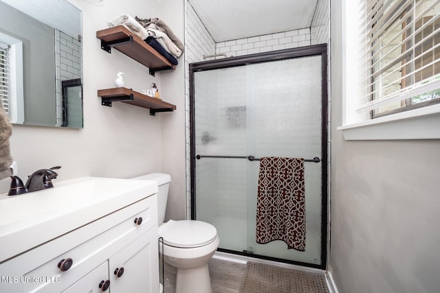 bathroom with toilet, a shower stall, vanity, and wood finished floors