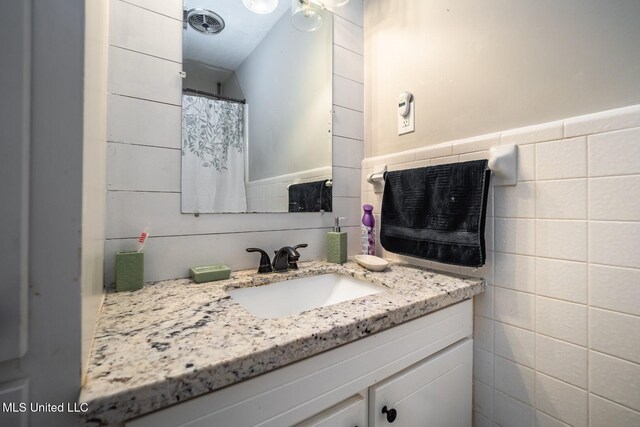 bathroom with tile walls and vanity