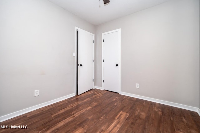 unfurnished bedroom featuring dark wood-type flooring, baseboards, and ceiling fan