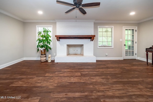 unfurnished living room with plenty of natural light, ornamental molding, a brick fireplace, a ceiling fan, and baseboards