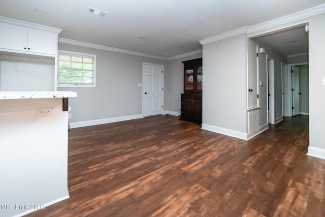 unfurnished living room with dark wood-style floors, crown molding, and baseboards