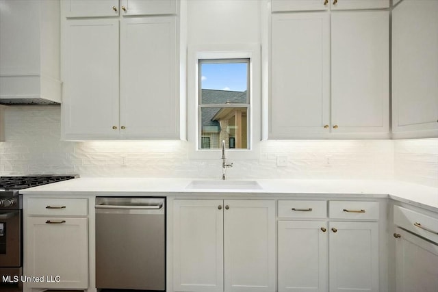 kitchen with a sink, tasteful backsplash, appliances with stainless steel finishes, and white cabinetry