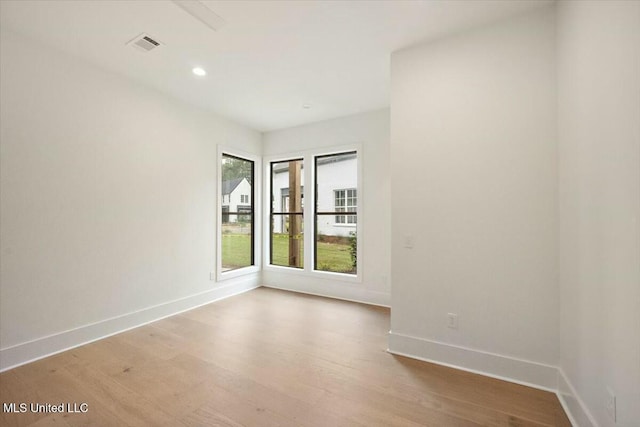 empty room featuring visible vents, baseboards, recessed lighting, and wood finished floors