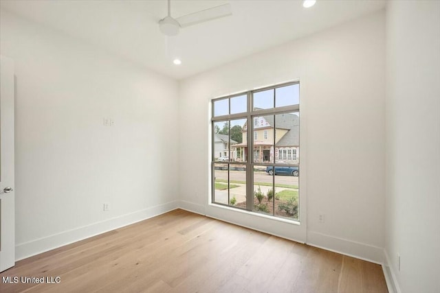 unfurnished room with light wood finished floors, baseboards, and recessed lighting