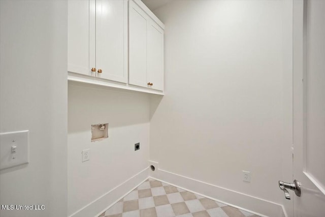 washroom featuring electric dryer hookup, light floors, washer hookup, baseboards, and cabinet space