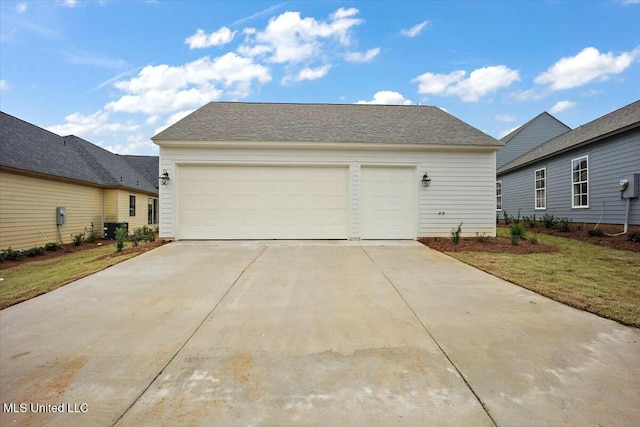 garage with central air condition unit and concrete driveway