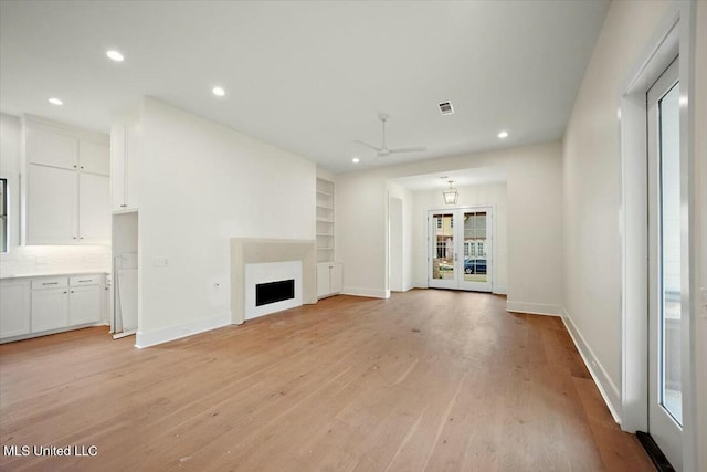 unfurnished living room with light wood-style floors, a fireplace, and recessed lighting