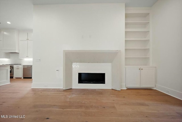 unfurnished living room featuring built in features, a fireplace, light wood-style flooring, recessed lighting, and baseboards