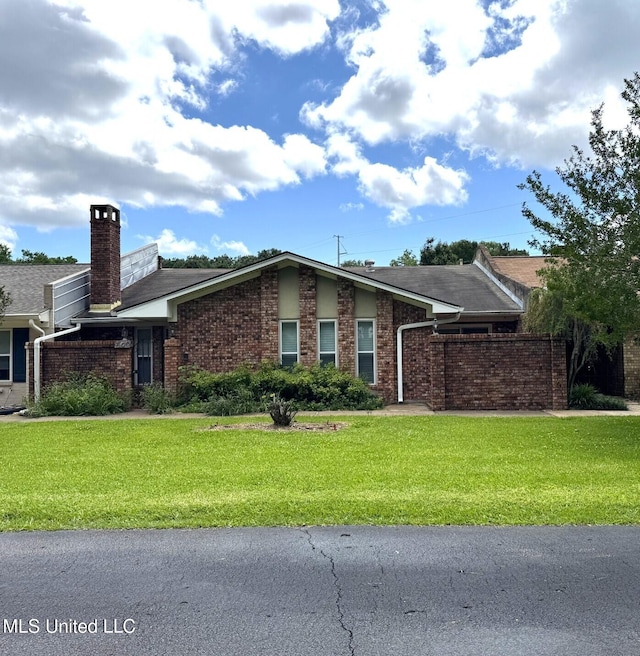 706 Melrose Montebello Pkwy, Natchez, MS 39120 - view of front facade featuring brick siding, a front yard, and a chimney
