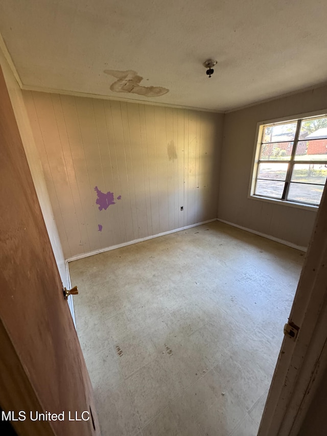 spare room with wood walls