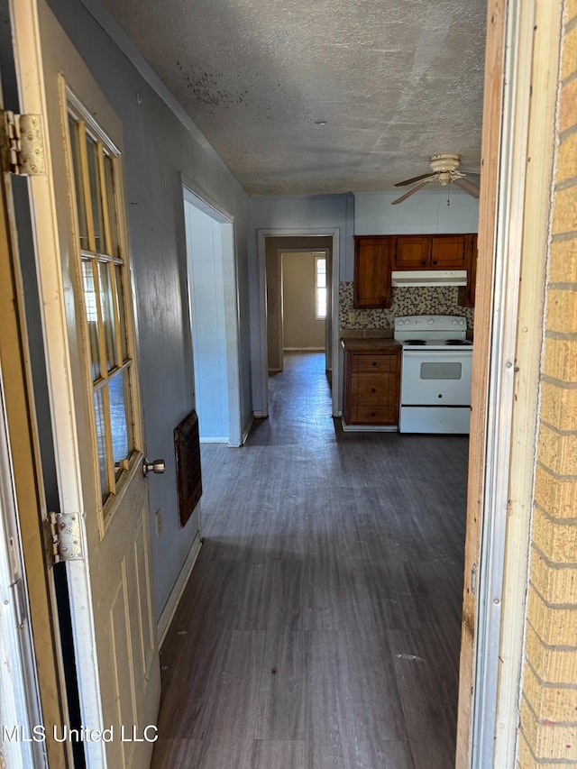 306 Hillcrest St, Carthage, MS 39051 - kitchen featuring white range with electric cooktop, under cabinet range hood, ceiling fan, brown cabinets, and heating unit