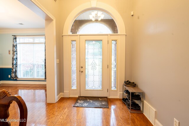 890 Lindsey Cv, Hernando, MS 38632 - entryway featuring a chandelier, wood finished floors, baseboards, and crown molding