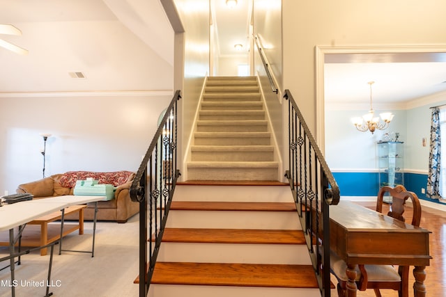 stairway featuring an inviting chandelier, ornamental molding, hardwood / wood-style floors, and a high ceiling