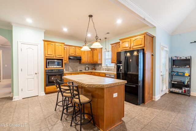 890 Lindsey Cv, Hernando, MS 38632 - kitchen featuring black appliances, a kitchen island, under cabinet range hood, arched walkways, and a sink