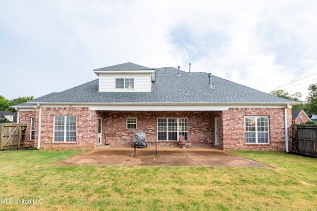 rear view of house with a patio and a lawn