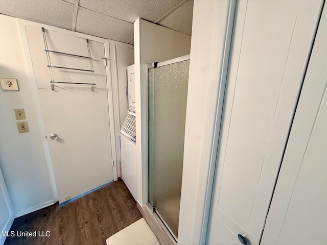 bathroom featuring a shower stall, a drop ceiling, and wood finished floors