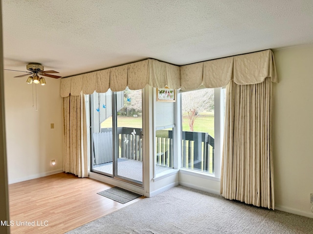 interior space featuring ceiling fan, a textured ceiling, and baseboards