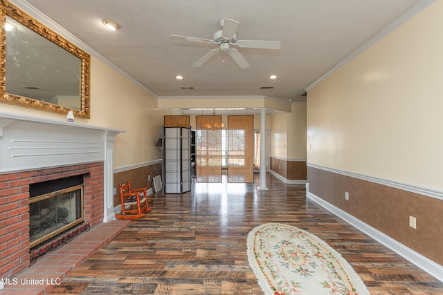 living room with decorative columns, ornamental molding, a brick fireplace, and dark hardwood / wood-style floors