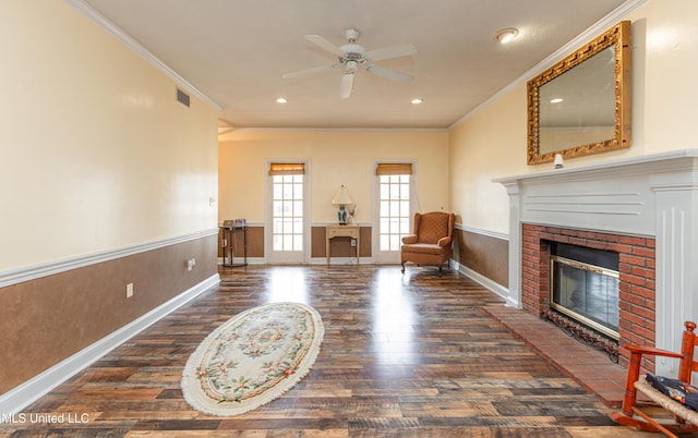 sitting room featuring ornamental molding, a brick fireplace, dark hardwood / wood-style floors, and ceiling fan