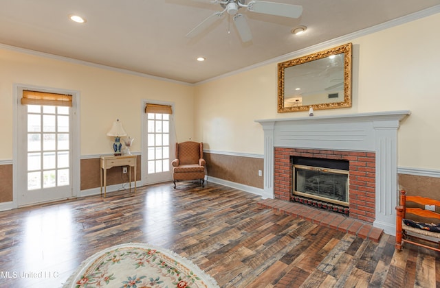 sitting room featuring crown molding, dark wood-type flooring, and a fireplace