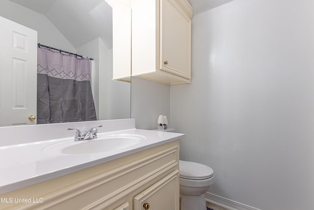 bathroom featuring vanity, lofted ceiling, and toilet