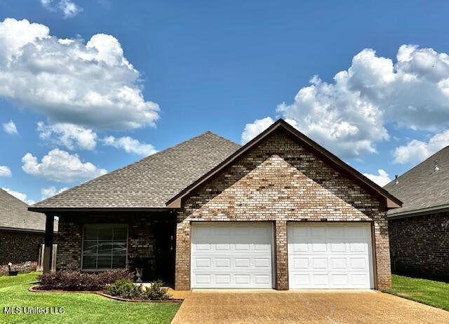648 Westhill Rd, Brandon, MS 39042 - view of front of house with concrete driveway, brick siding, a garage, a front lawn, and roof with shingles