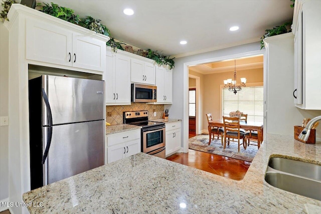 648 Westhill Rd, Brandon, MS 39042 - kitchen with appliances with stainless steel finishes, a sink, a chandelier, backsplash, and white cabinets