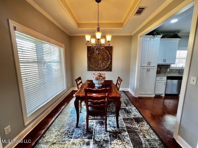 648 Westhill Rd, Brandon, MS 39042 - dining space with a chandelier, a tray ceiling, crown molding, baseboards, and dark tile patterned flooring