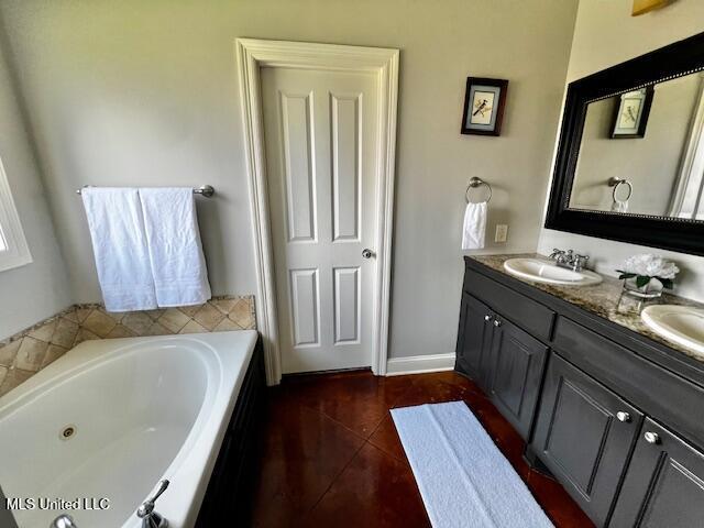 648 Westhill Rd, Brandon, MS 39042 - full bath with double vanity, a jetted tub, tile patterned floors, and baseboards