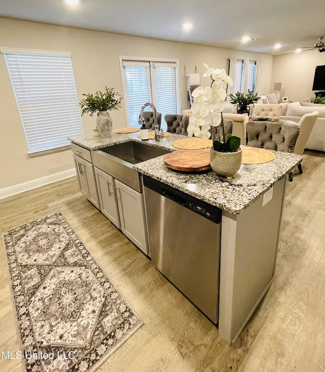 5438 Leeds Ln, Biloxi, MS 39532 - kitchen featuring light stone counters, stainless steel dishwasher, open floor plan, and an island with sink