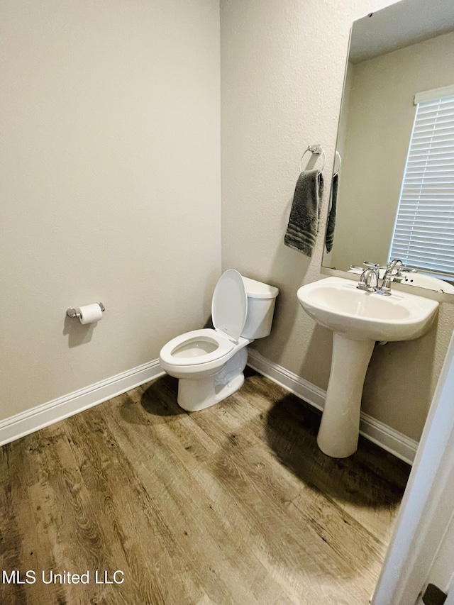 5438 Leeds Ln, Biloxi, MS 39532 - bathroom featuring toilet, baseboards, a sink, and wood finished floors