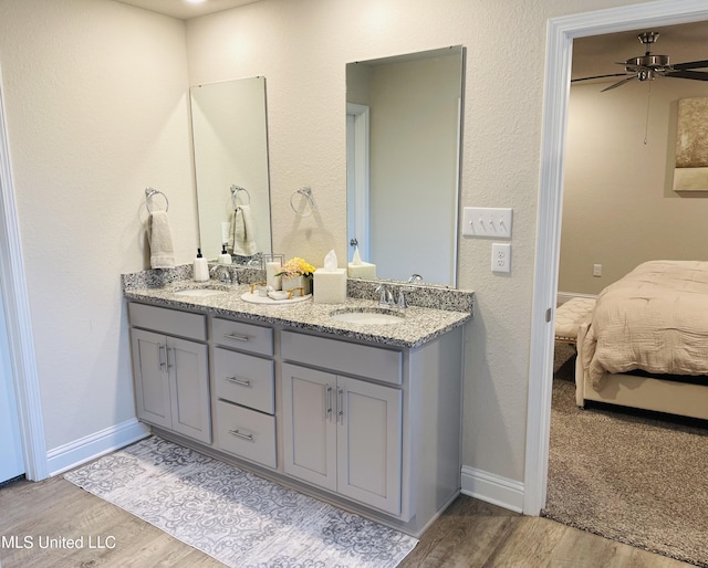 5438 Leeds Ln, Biloxi, MS 39532 - ensuite bathroom with double vanity, a sink, ensuite bath, and wood finished floors
