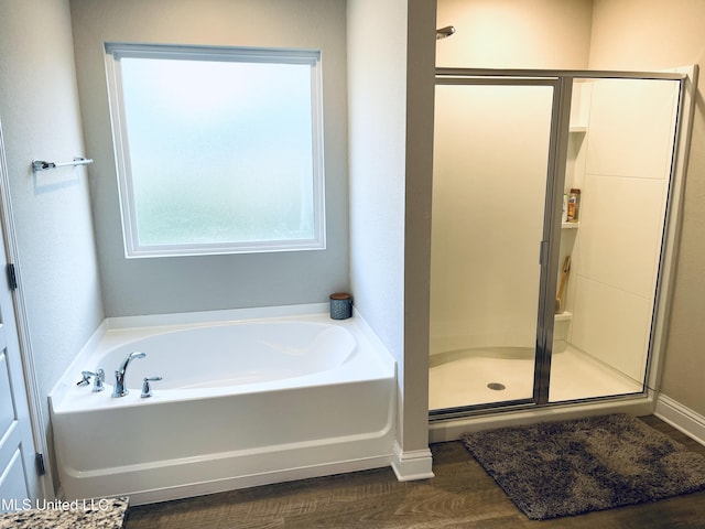 5438 Leeds Ln, Biloxi, MS 39532 - bathroom featuring baseboards, wood finished floors, a garden tub, and a stall shower