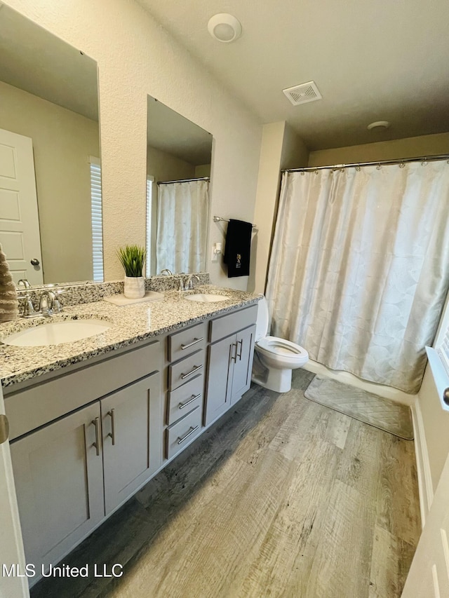 5438 Leeds Ln, Biloxi, MS 39532 - full bath featuring toilet, visible vents, a sink, and wood finished floors