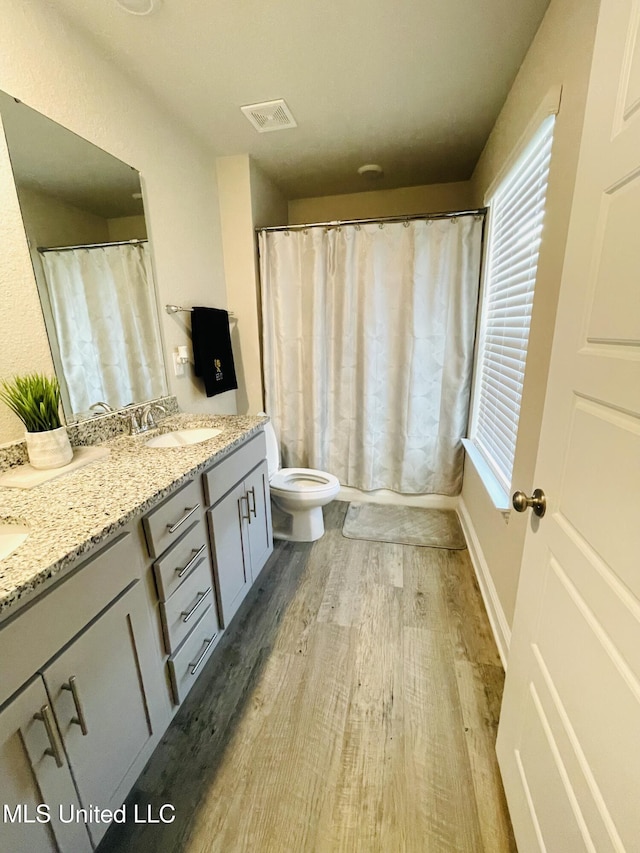 5438 Leeds Ln, Biloxi, MS 39532 - bathroom featuring vanity, toilet, curtained shower, wood finished floors, and visible vents
