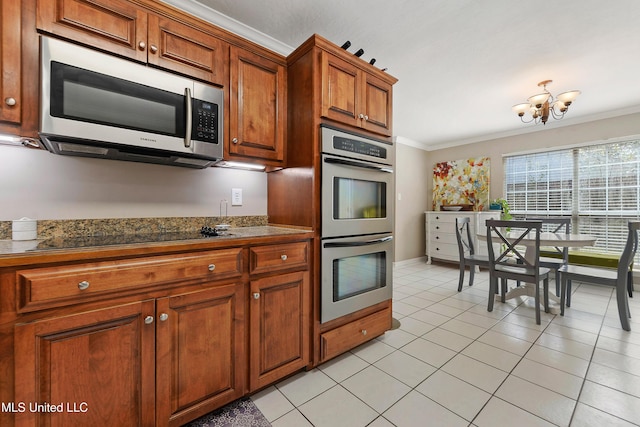 kitchen featuring ornamental molding, stainless steel appliances, an inviting chandelier, brown cabinetry, and light tile patterned floors