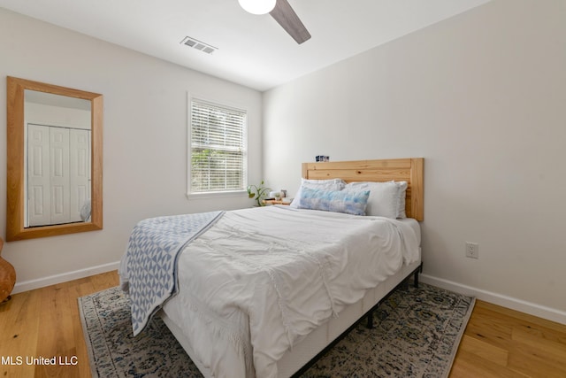 bedroom featuring wood finished floors, visible vents, and baseboards