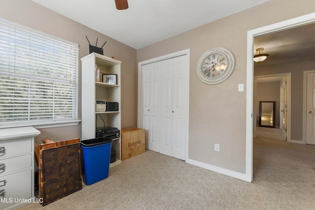 carpeted bedroom with a closet, baseboards, and ceiling fan