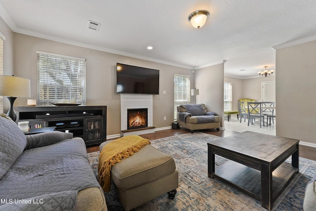 living area featuring visible vents, baseboards, a warm lit fireplace, and crown molding