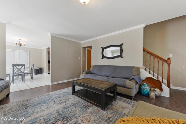 living room with ornamental molding, wood finished floors, an inviting chandelier, baseboards, and stairs