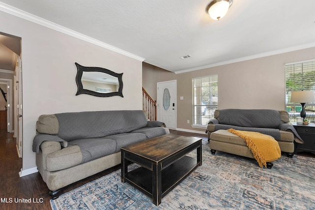 living area featuring wood finished floors, visible vents, baseboards, stairs, and crown molding