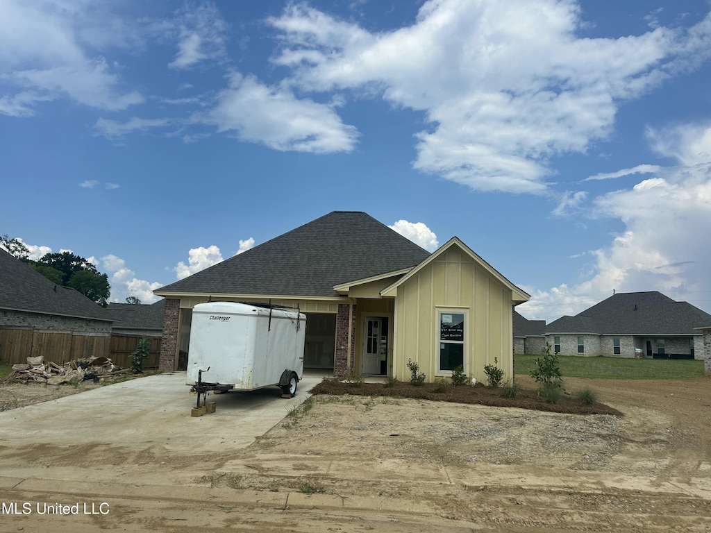 330 Willow Way, Canton, MS 39046 - view of front of house with concrete driveway, an attached garage, board and batten siding, roof with shingles, and brick siding