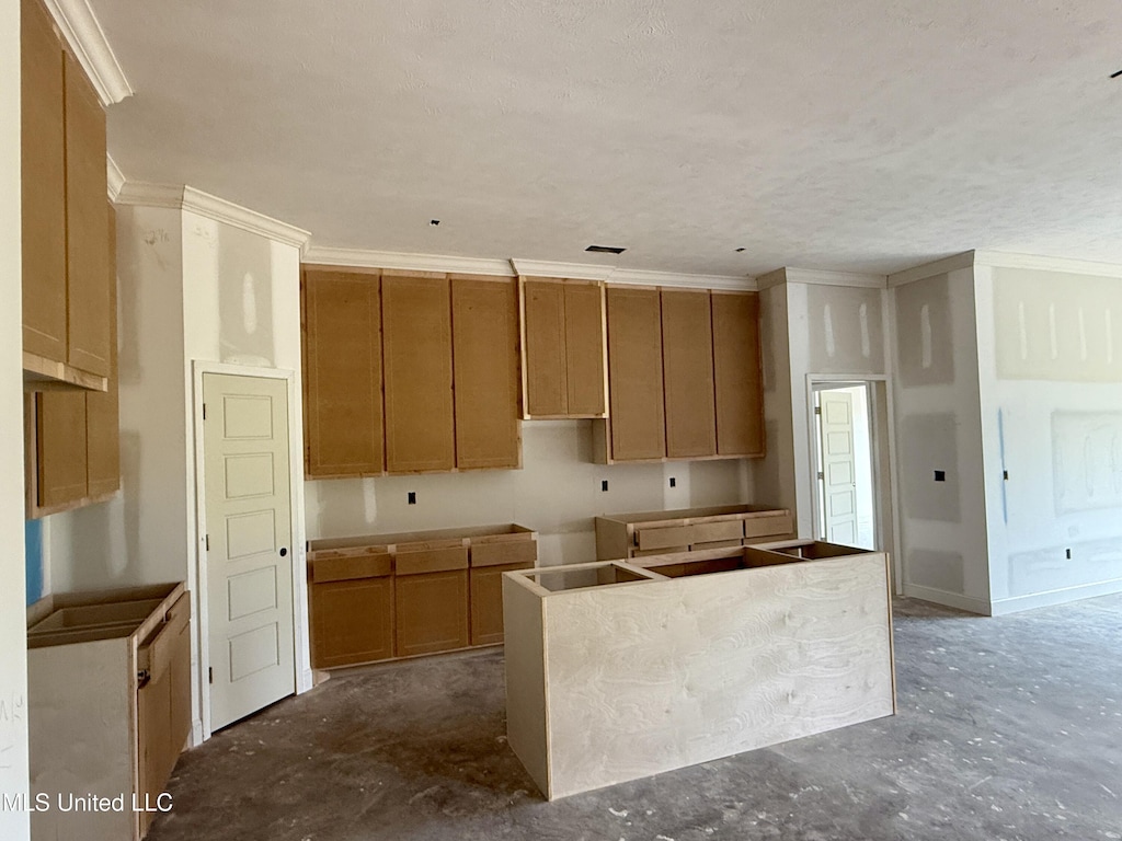 330 Willow Way, Canton, MS 39046 - kitchen featuring a kitchen island, crown molding, and brown cabinets