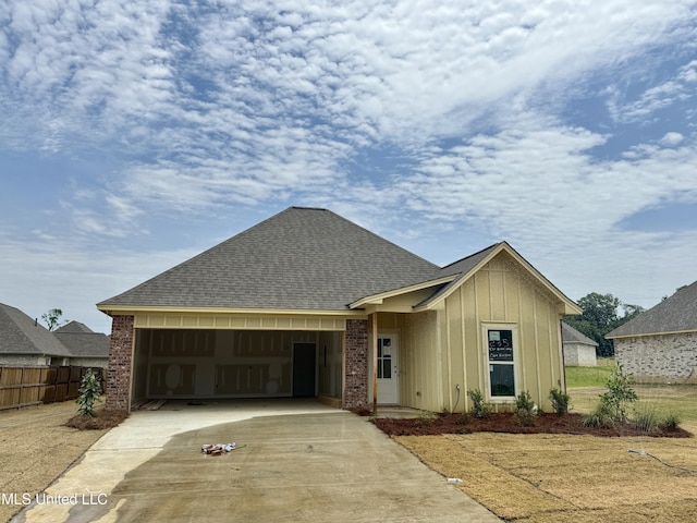 330 Willow Way, Canton, MS 39046 - view of front of house featuring board and batten siding, an attached garage, driveway, a shingled roof, and brick siding