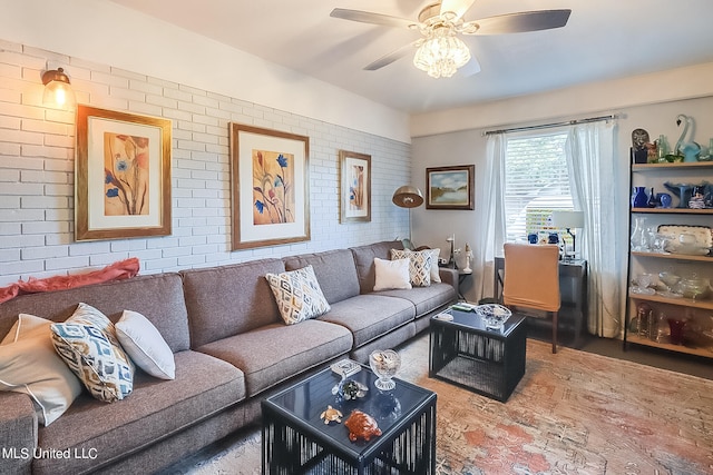 living room featuring ceiling fan and brick wall