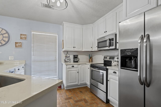 kitchen with white cabinetry, tasteful backsplash, stainless steel appliances, and a textured ceiling