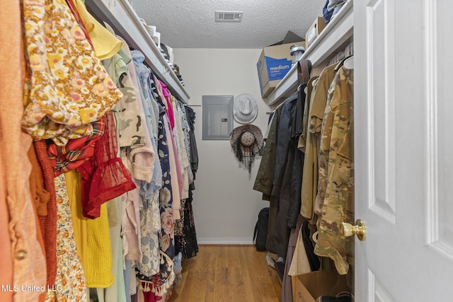 spacious closet featuring electric panel and light wood-type flooring