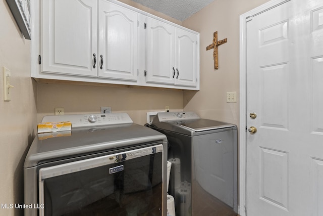 laundry area featuring cabinets, washing machine and dryer, and a textured ceiling